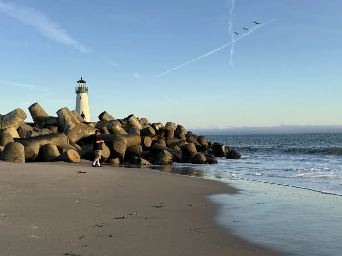 Casting a line from the sand at the base of the harbor jetty