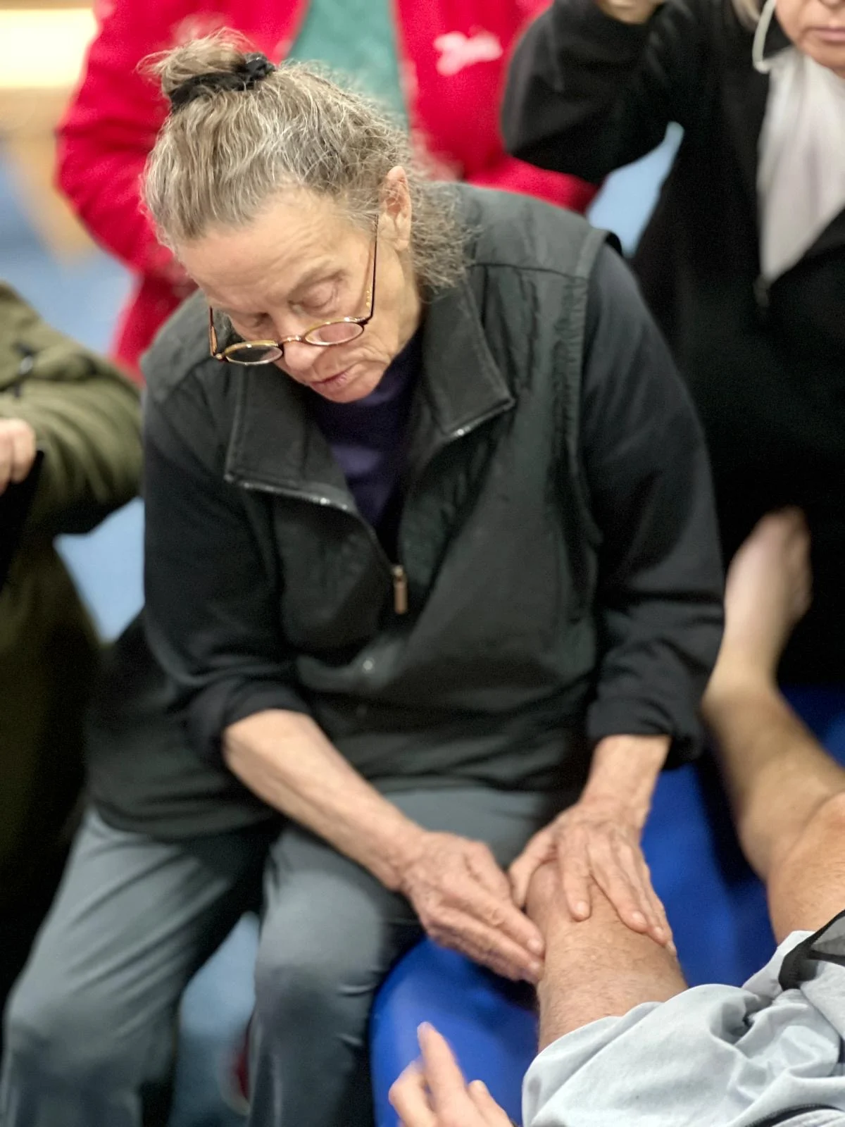 Sharon Wheeler demonstrating presence-based bodywork with a veteran in Ukraine